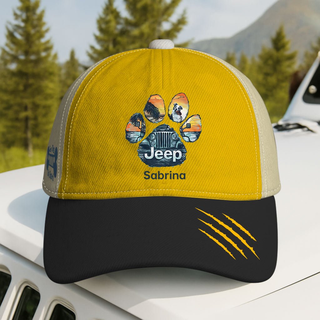 Yellow and black cap with Jeep logo and paw print design on a vehicle roof with a forest background