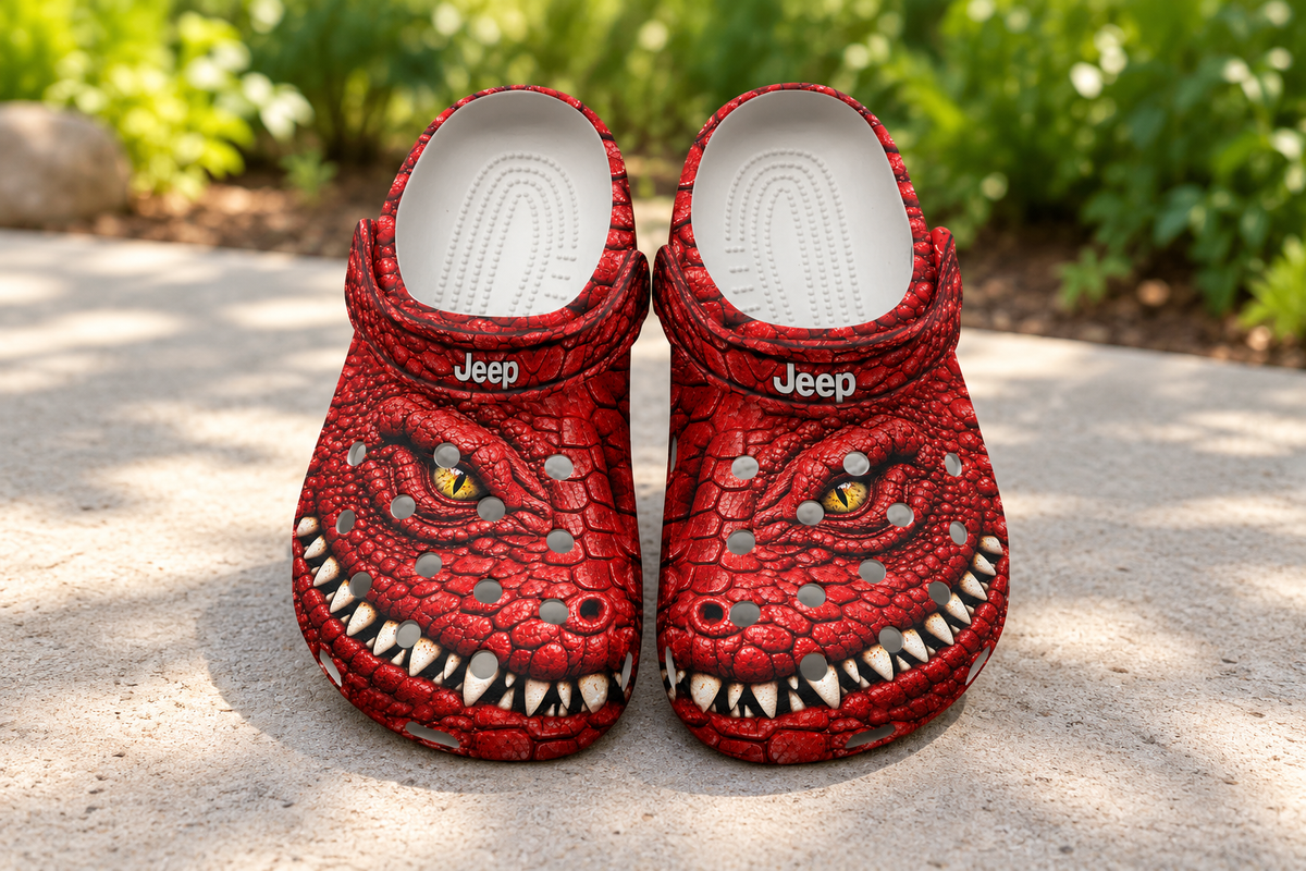 Red Jeep Crocodile Clogs with printed reptile graphics on a garden patio